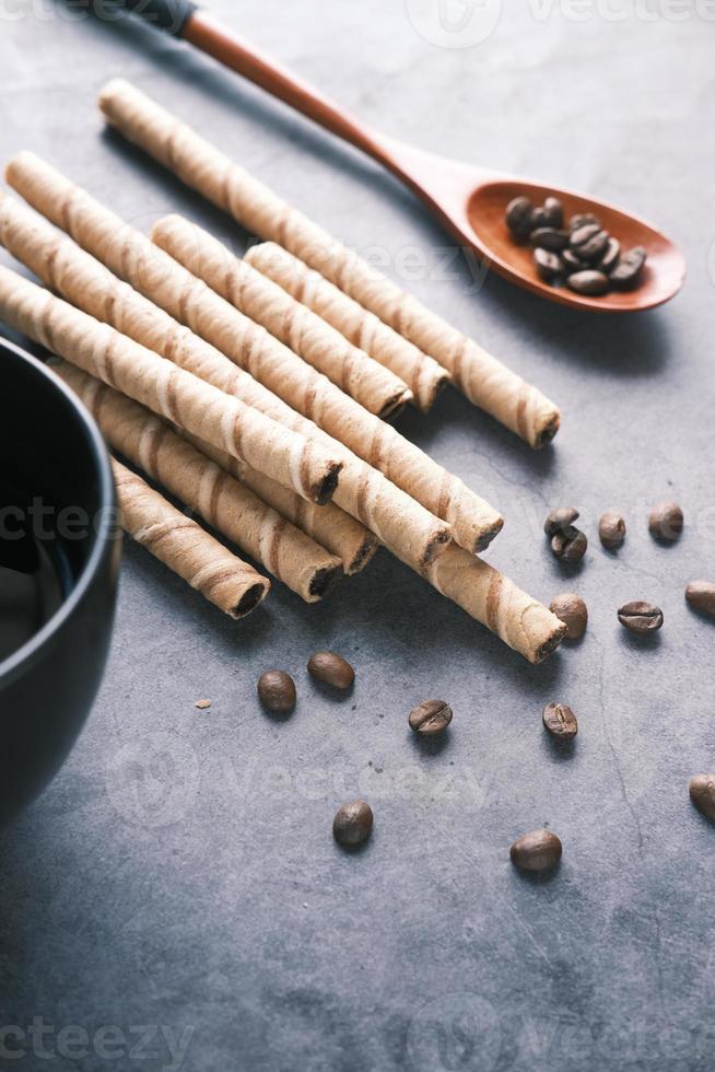 wafer roll cioccolato , chicchi di caffè e tazza da caffè sul tavolo , foto