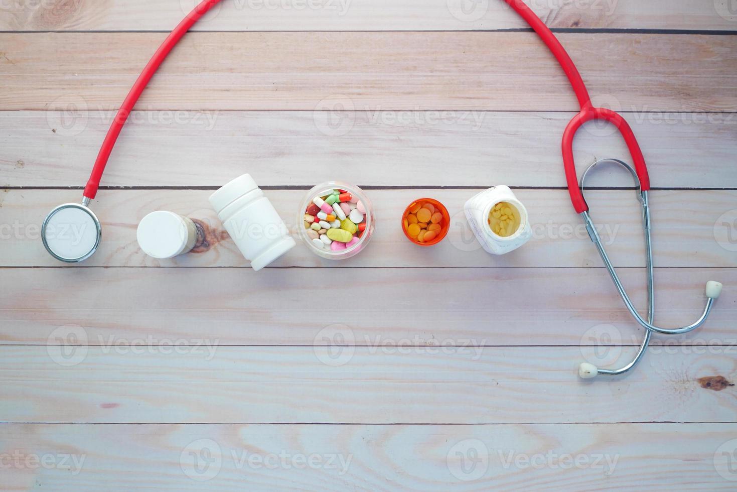 vista dall'alto di contenitori per pillole mediche e stetoscopio sul tavolo foto