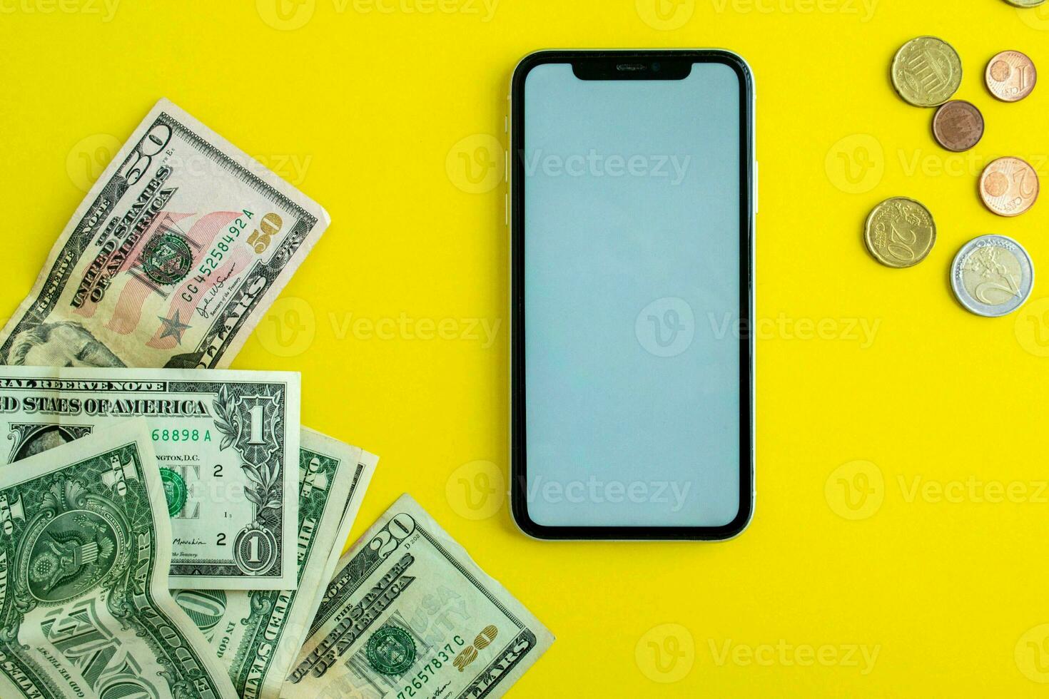 modello, smartphone, dollari banconote e Euro monete su un' giallo sfondo foto