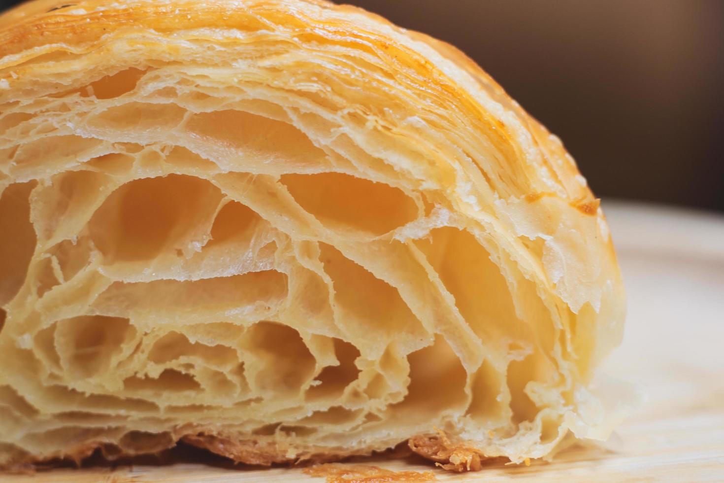 i croissant sono posti su un fondo di legno. prodotti da forno su sfondo isolato foto