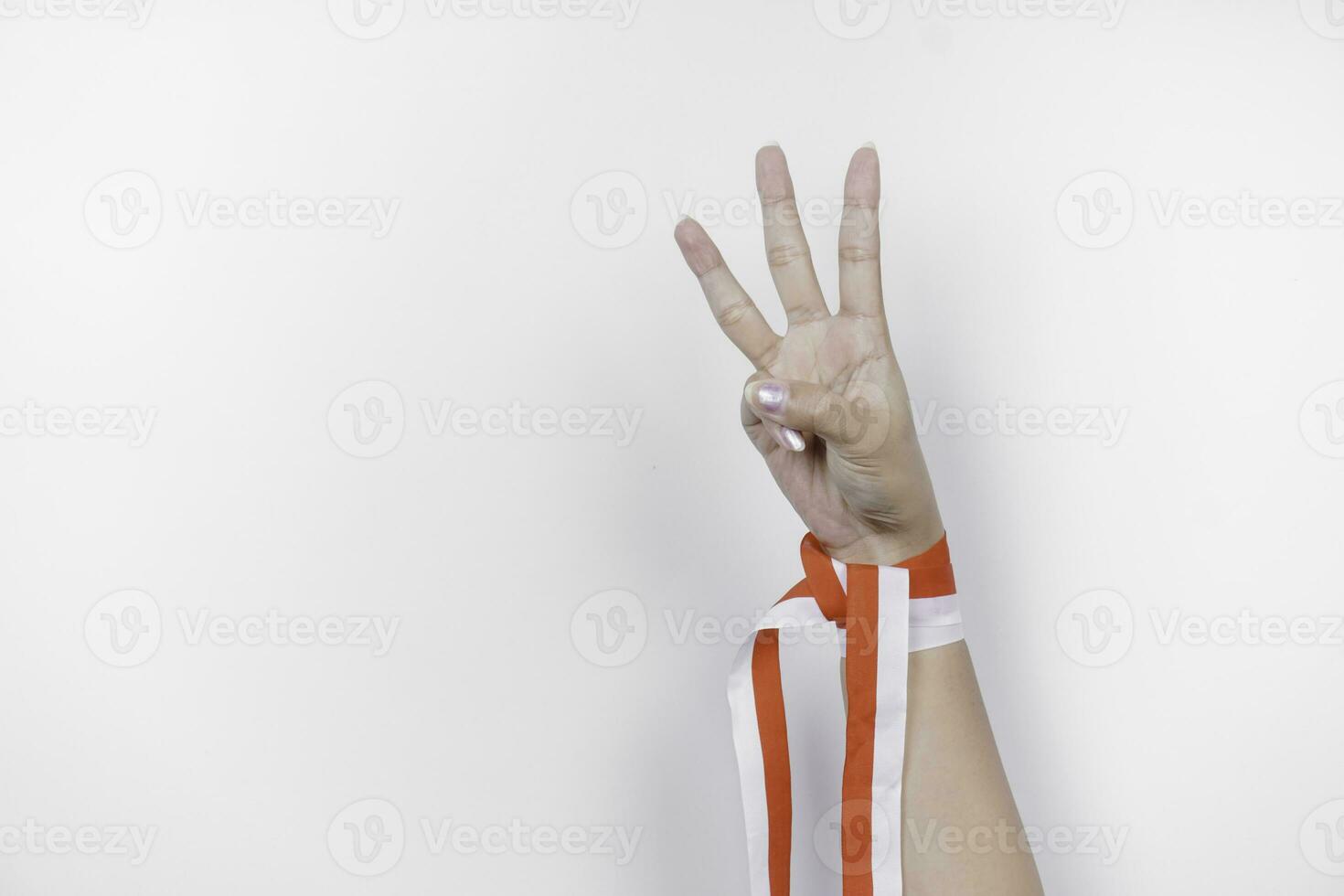 mani Esprimere a gesti segni di numero indossare indonesiano rosso e bianca nastro. dell'Indonesia indipendenza giorno concetto foto