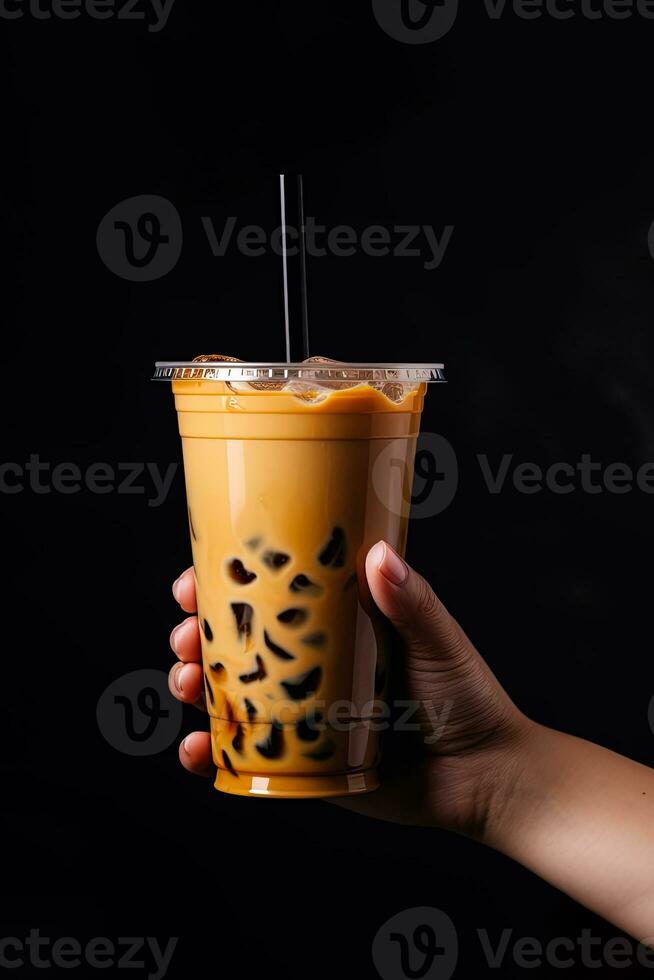 un' mano Tenere porta via plastica tazza di delizioso ghiacciato bolla latte tè e nero perle isolato su nero sfondo. ai generato foto