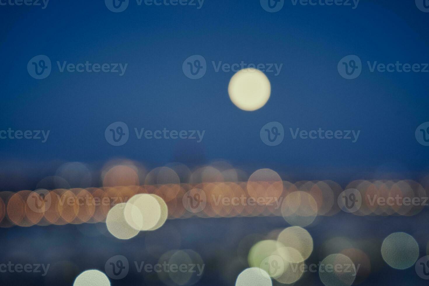 bokeh fotografia di il Luna e luci di il città di siviglia foto