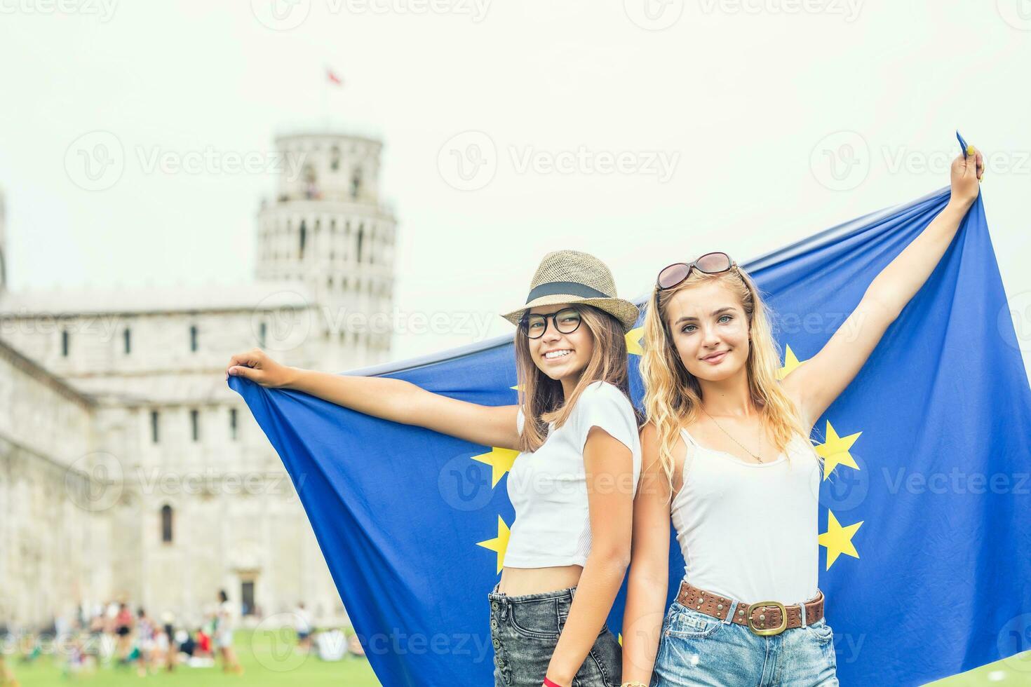 giovane adolescente ragazze viaggiatore con bandiera di europeo unione prima il storico Torre nel cittadina pisa - Italia foto