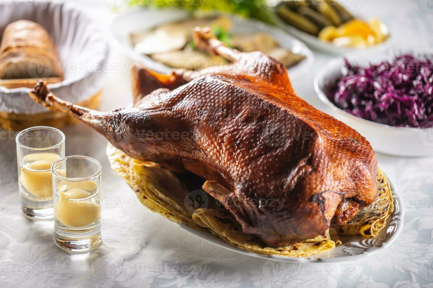 arrosto Oca con lato piatti, rosso cavolo, arrosto, strudel, Patata Ravioli, sottaceti pane e Pera distillato foto