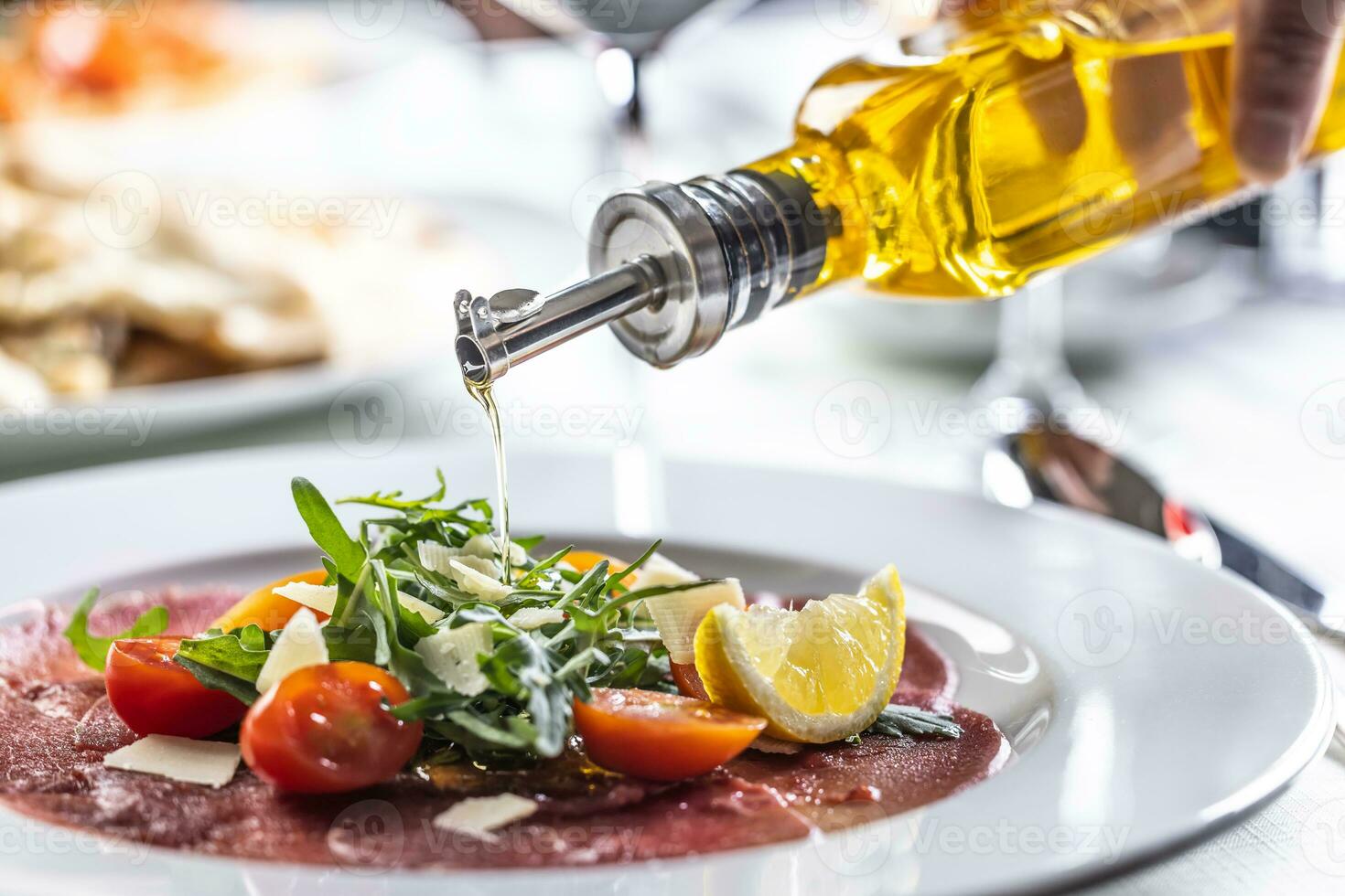 oliva olio versato al di sopra di un' scosso insalata nel un' carpaccio aperitivo foto