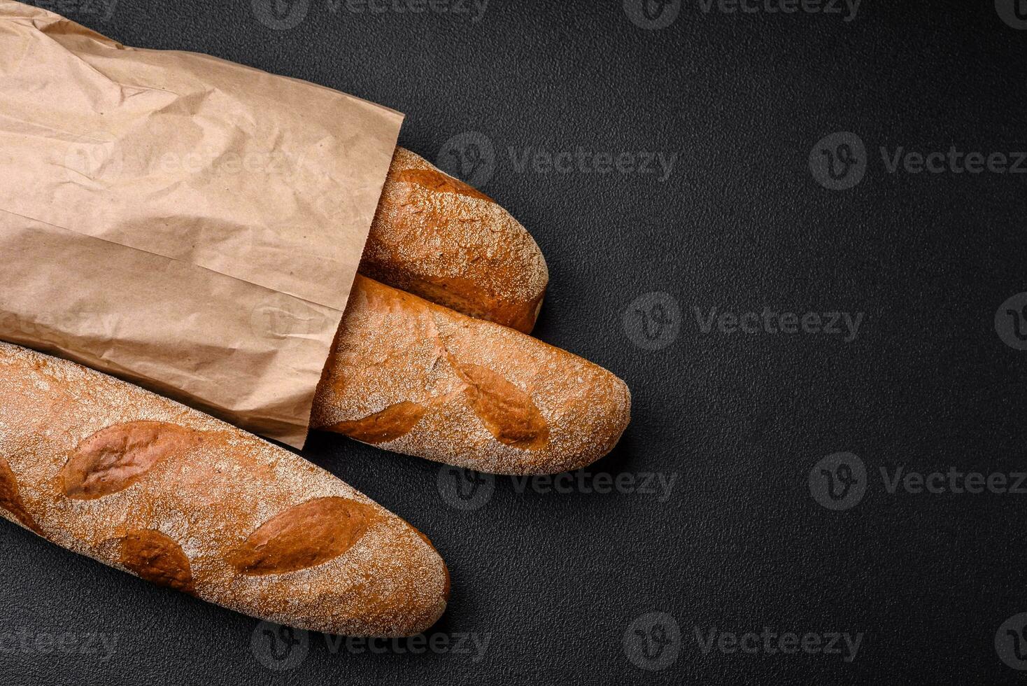 francese baguette pane su un' buio strutturato calcestruzzo sfondo foto