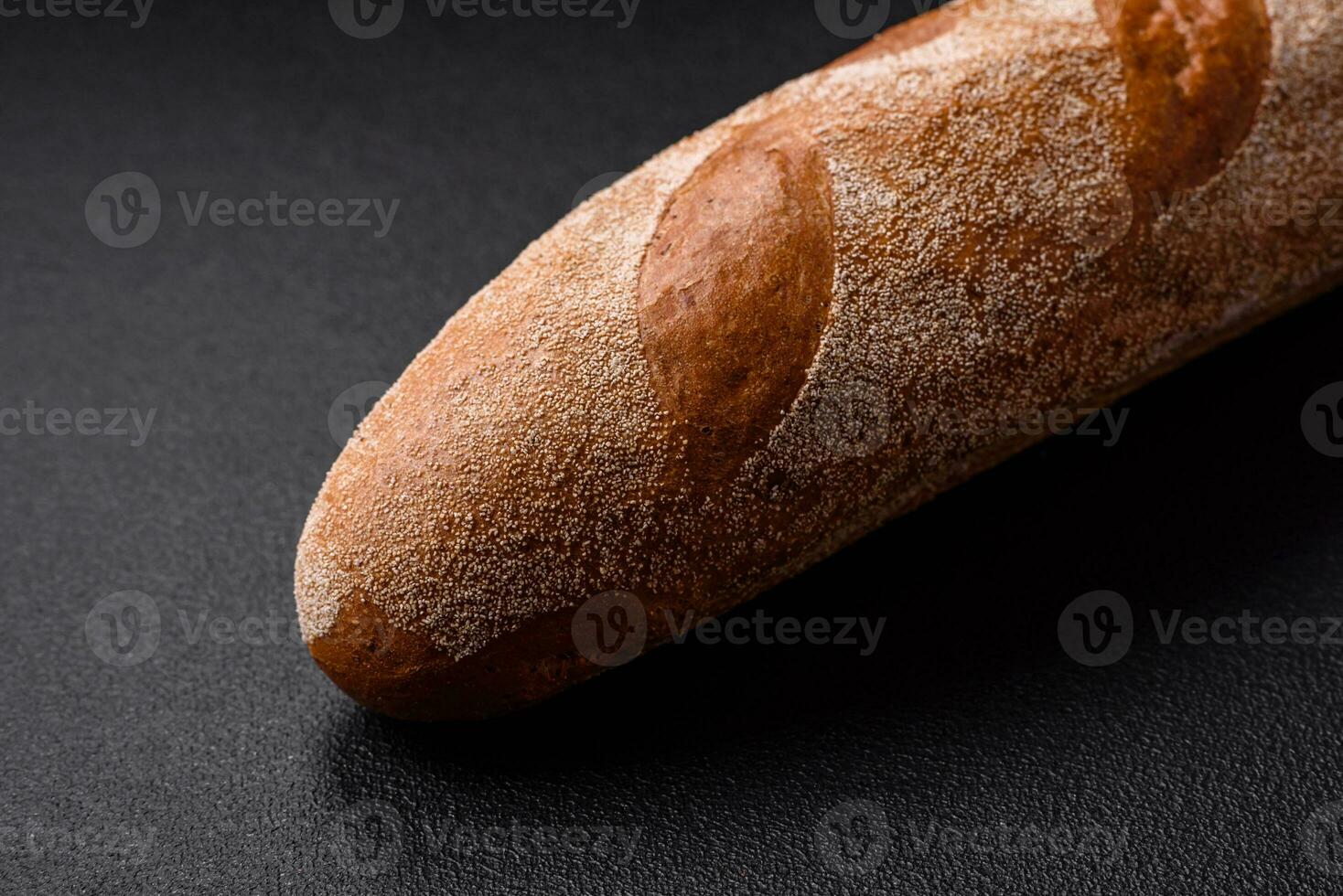 francese baguette pane su un' buio strutturato calcestruzzo sfondo foto