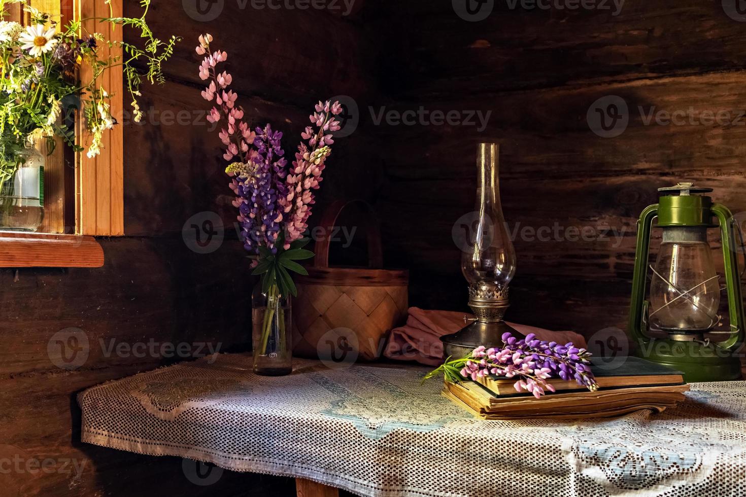 natura morta di oggetti vintage e un mazzo di lupini su un tavolo foto