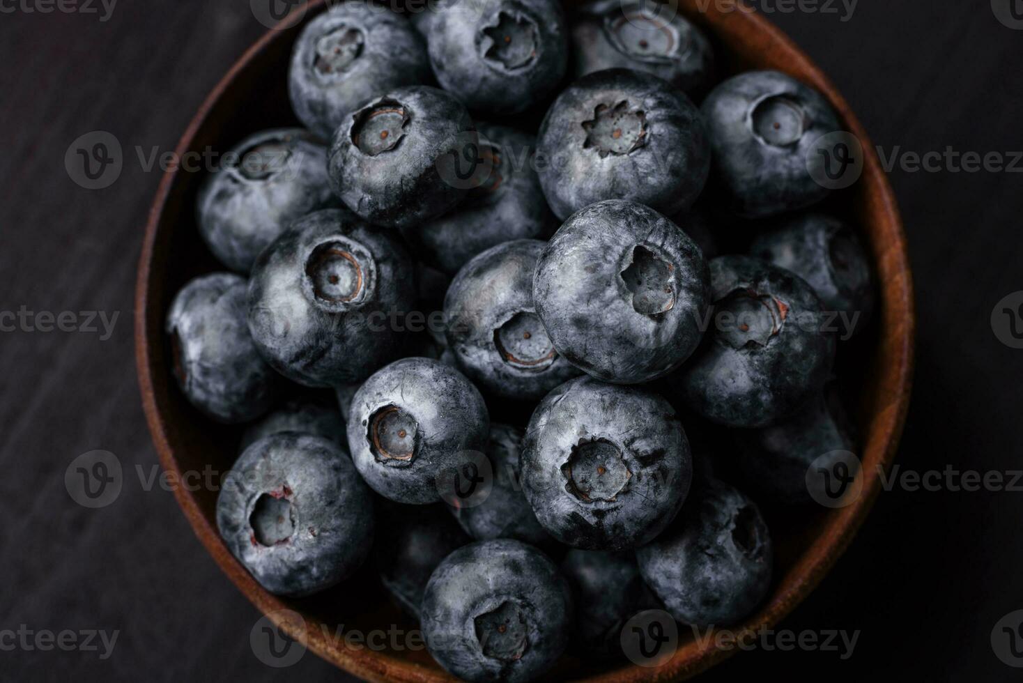 delizioso fresco dolce mirtilli nel un' ceramica ciotola. vegano cibo foto