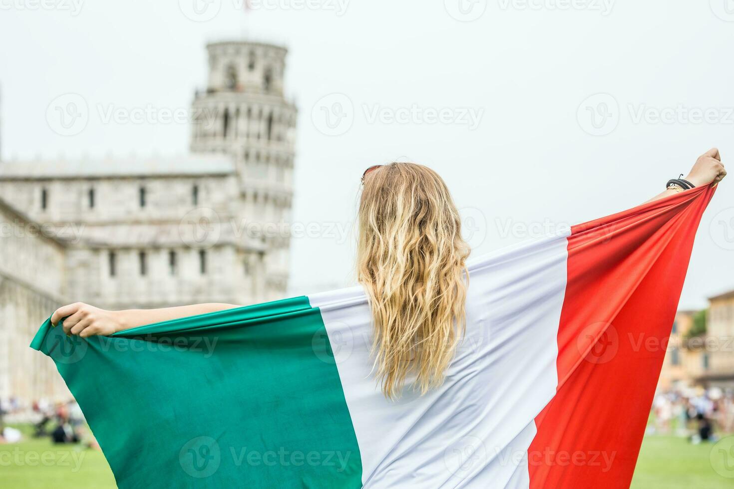 giovane adolescente ragazza viaggiatore con italiano bandiera prima il storico Torre nel cittadina pisa - Italia foto