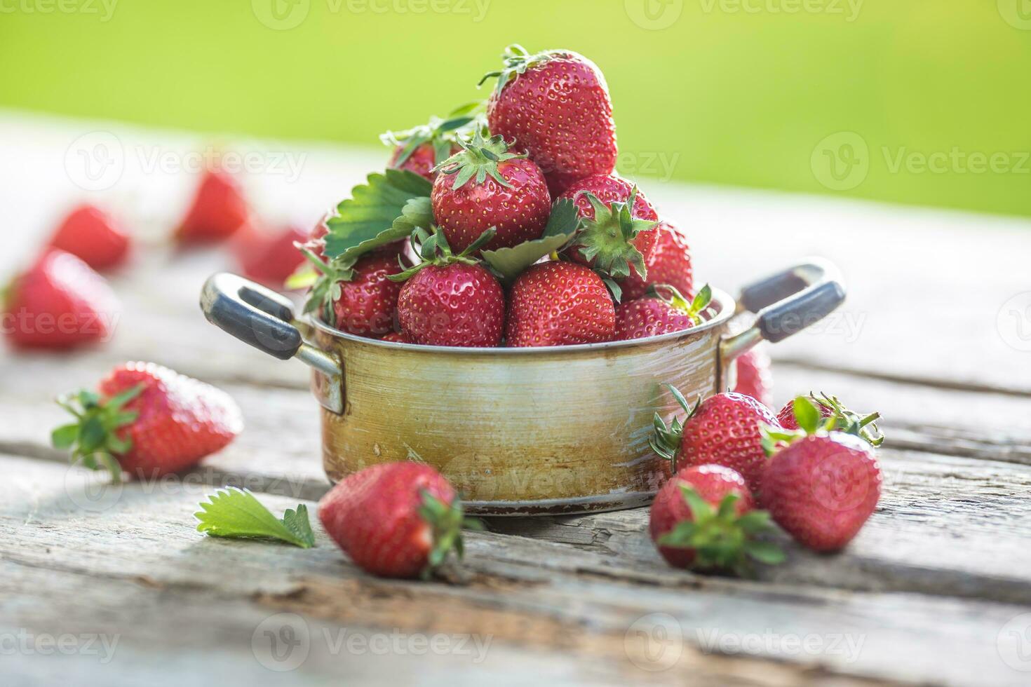 fresco maturo fragole nel Vintage ▾ cucina pentola su vecchio giardino tavolo foto