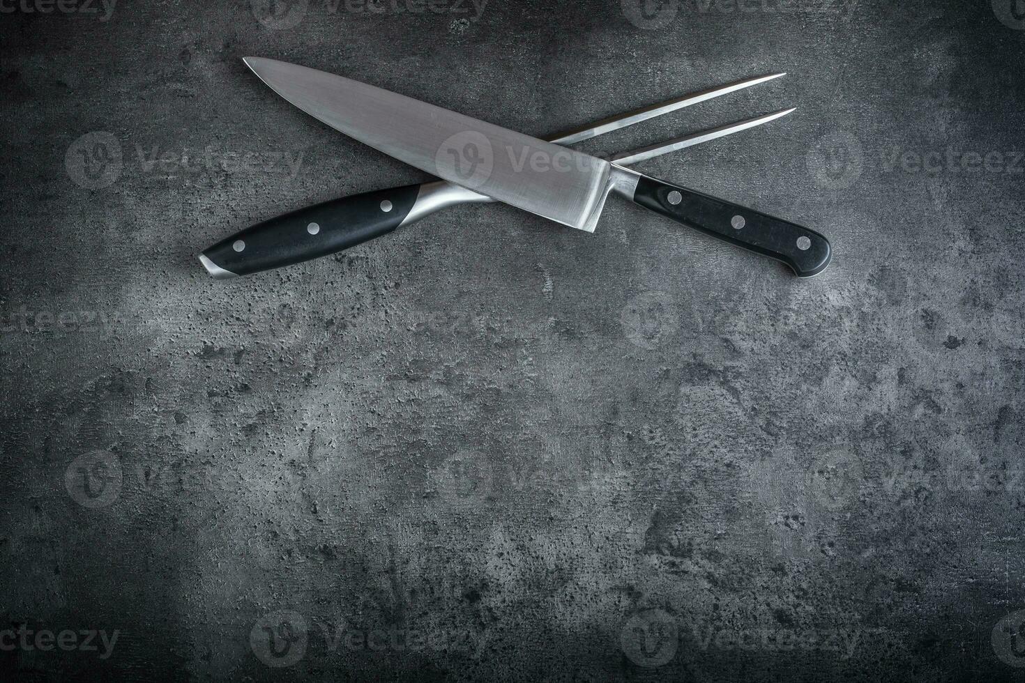 forchetta e coltello. forchetta e coltello attraversato su calcestruzzo tavola foto