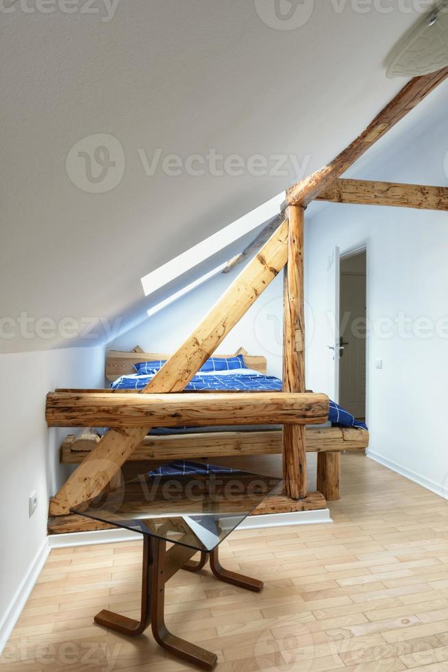 appartamento mansardato, camera da letto moderna, interior design appartamento con vecchie travi in legno rustico, pavimenti e mobili. foto