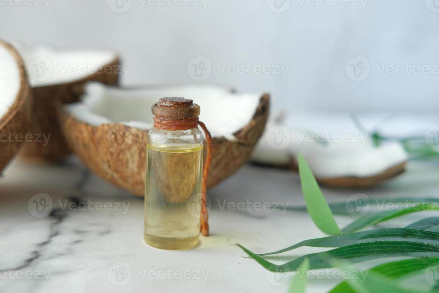 fetta di cocco fresco e bottiglia di olio su un tavolo foto