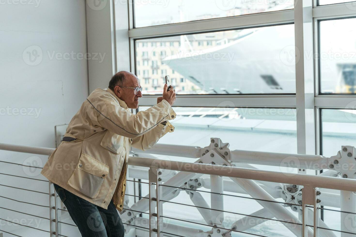 mezzo età Calvo uomo assunzione foto con inteligente Telefono nel in attesa camera a porta - contento turista in viaggio di crociera nave