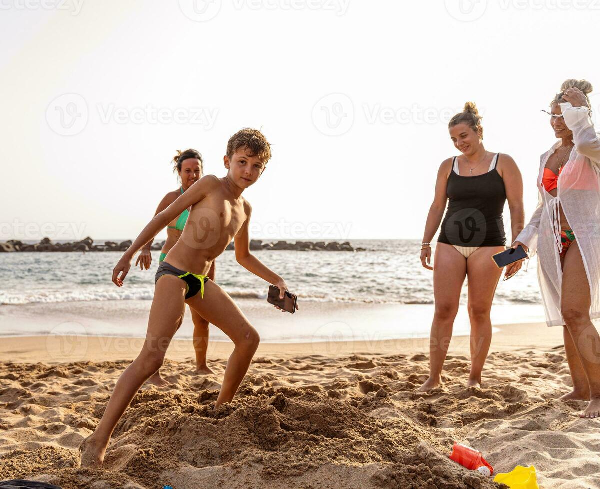 famiglia su vacanza giocando con sabbia castelli su il spiaggia a tramonto foto
