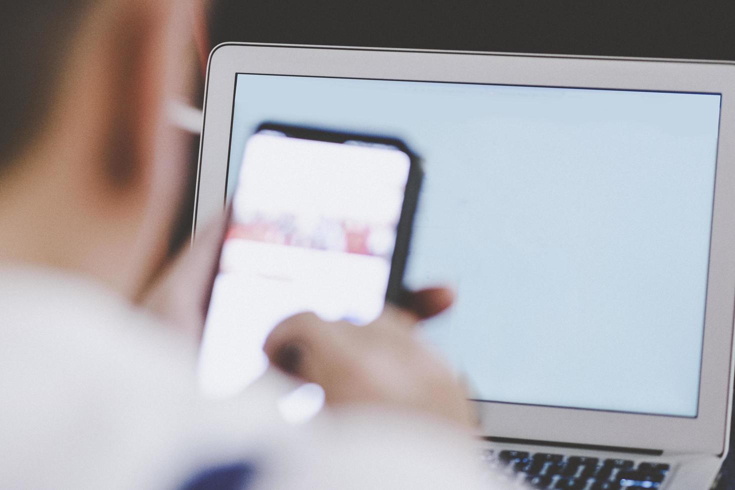 uomo che utilizza il suo smartphone e laptop alla conferenza di lavoro. successo e concetto di business. foto