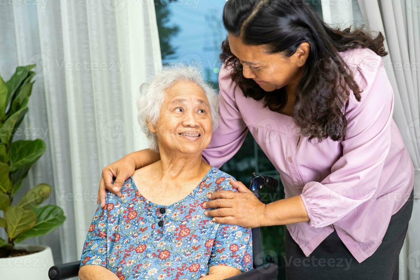 badante Aiuto asiatico anziano donna su sedia a rotelle con amore a casa. foto