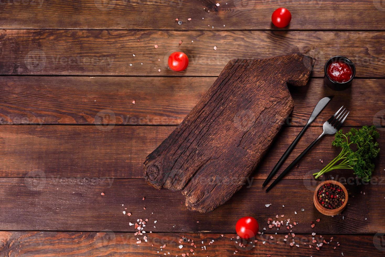 tagliere di legno, verdure e uno speciale tavolo scuro foto