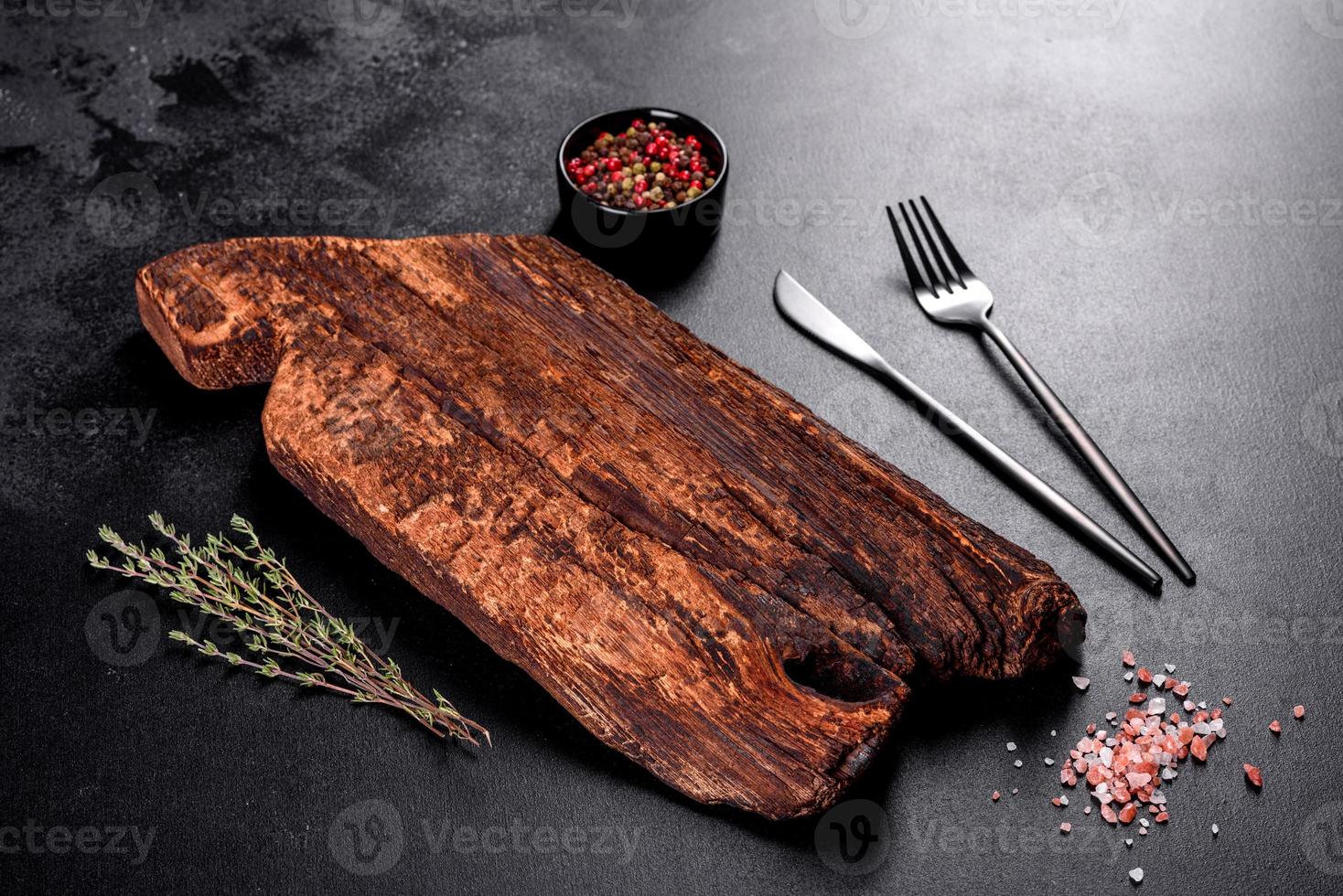 tagliere di legno, verdure e uno speciale tavolo scuro foto