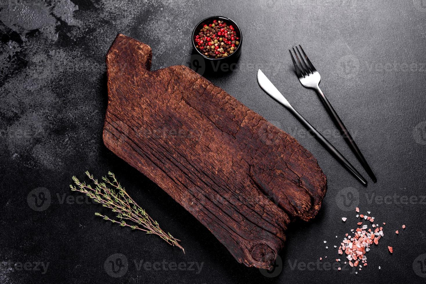 tagliere di legno, verdure e uno speciale tavolo scuro foto