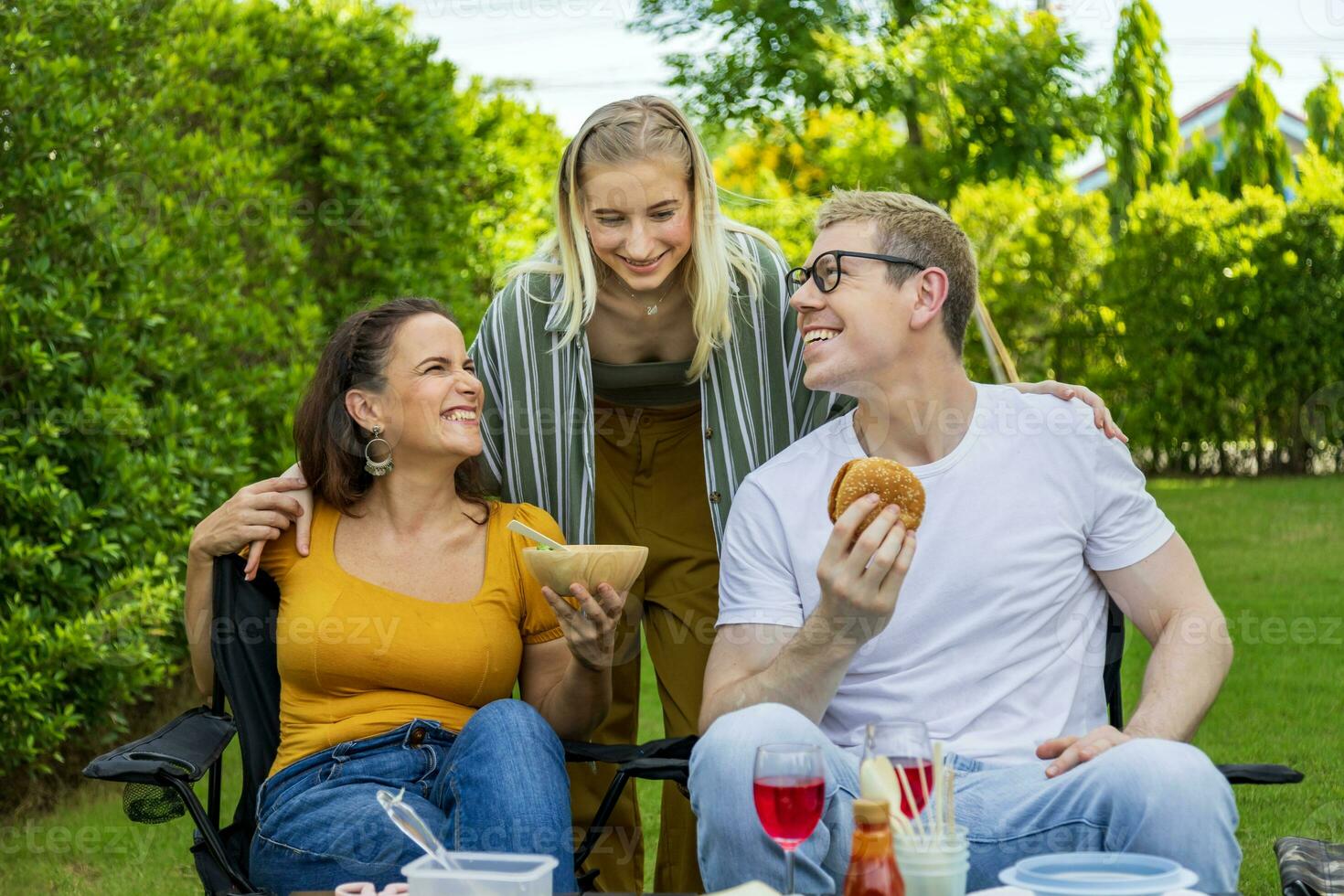 famiglia con madre e sua bambini Compreso fratello e sorella avendo bbq picnic vacanza a loro Giardino dietro la casa durante estate mentre avendo bene cibo e tempo insieme per amore e fratello concetto foto