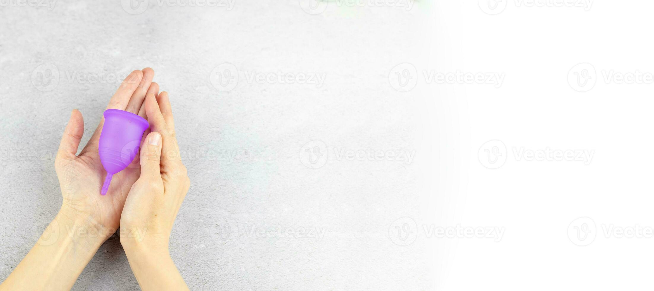 avvicinamento di un' donna di mani Tenere un' silicone mestruale tazza. alternativa ecologico femminile igiene Prodotto durante mestruazione senza sprechi concetto. bandiera con spazio per testo foto