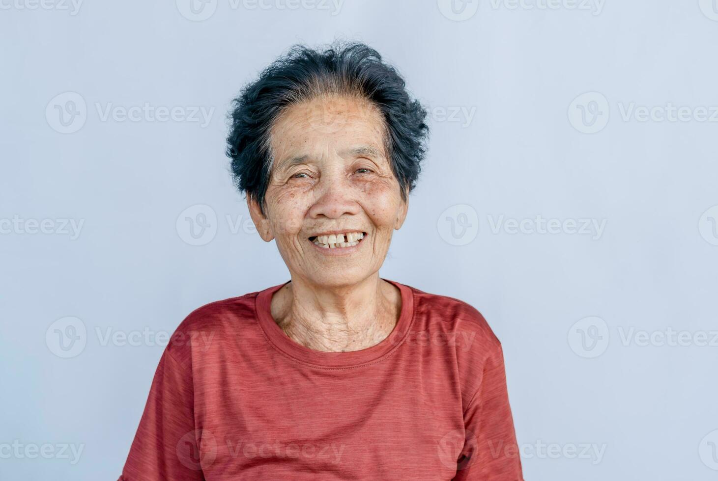 avvicinamento di vecchio asiatico donna viso con rughe anziano anziano e sorridente felicità con un' pochi rotto denti guardare a il telecamera. Salute cura concetto. dentista foto