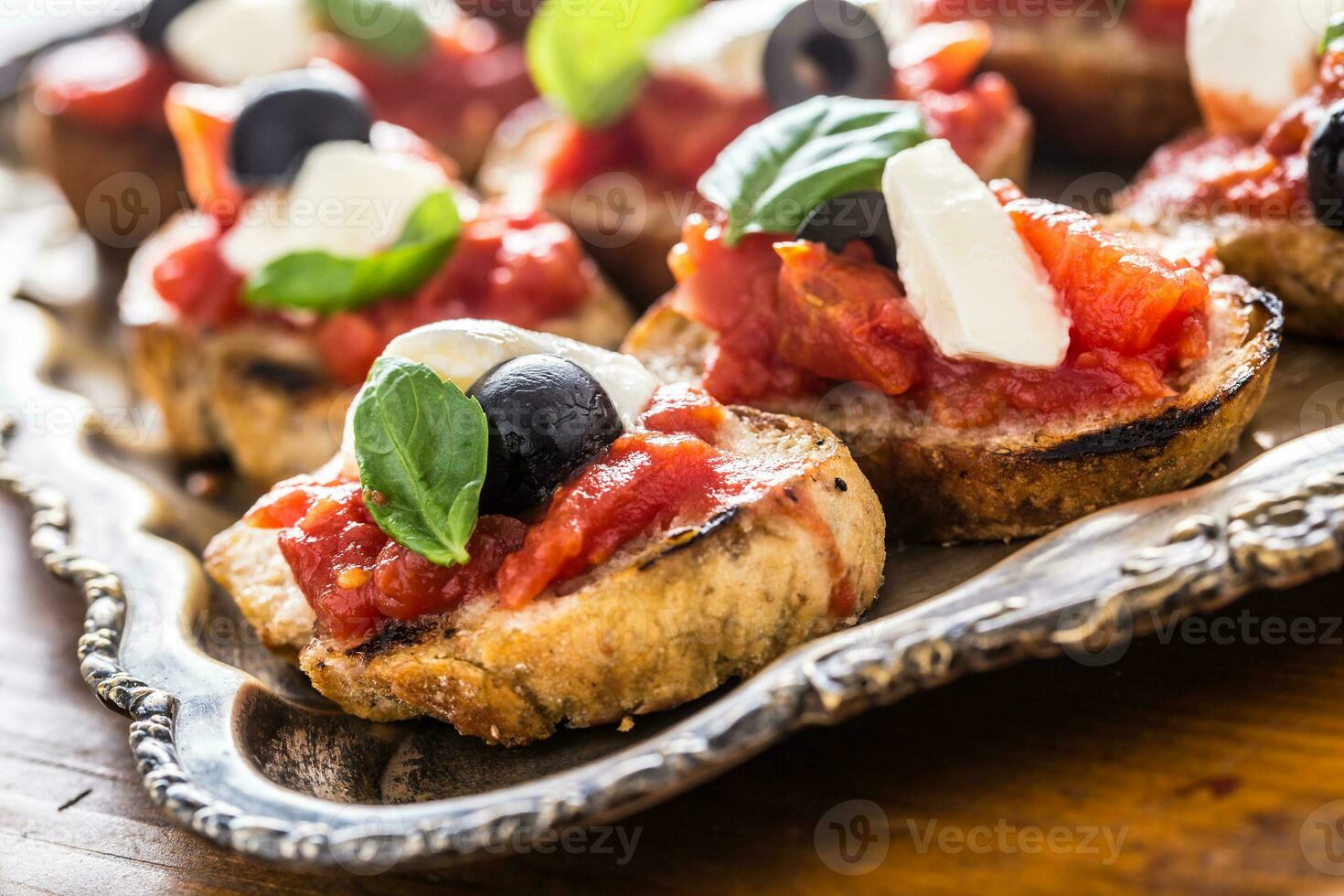 Bruschetta crostini con Mozzarella pomodori olive e basilico. foto