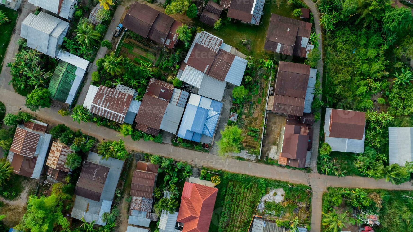 aereo Visualizza di un' sereno rurale villaggio con verde giardino nel nord-est Tailandia. tranquillo paesaggio e autentico culturale eredità. rurale Comunità nel Tailandia con vecchio zincato tetto. rurale costruzione. foto