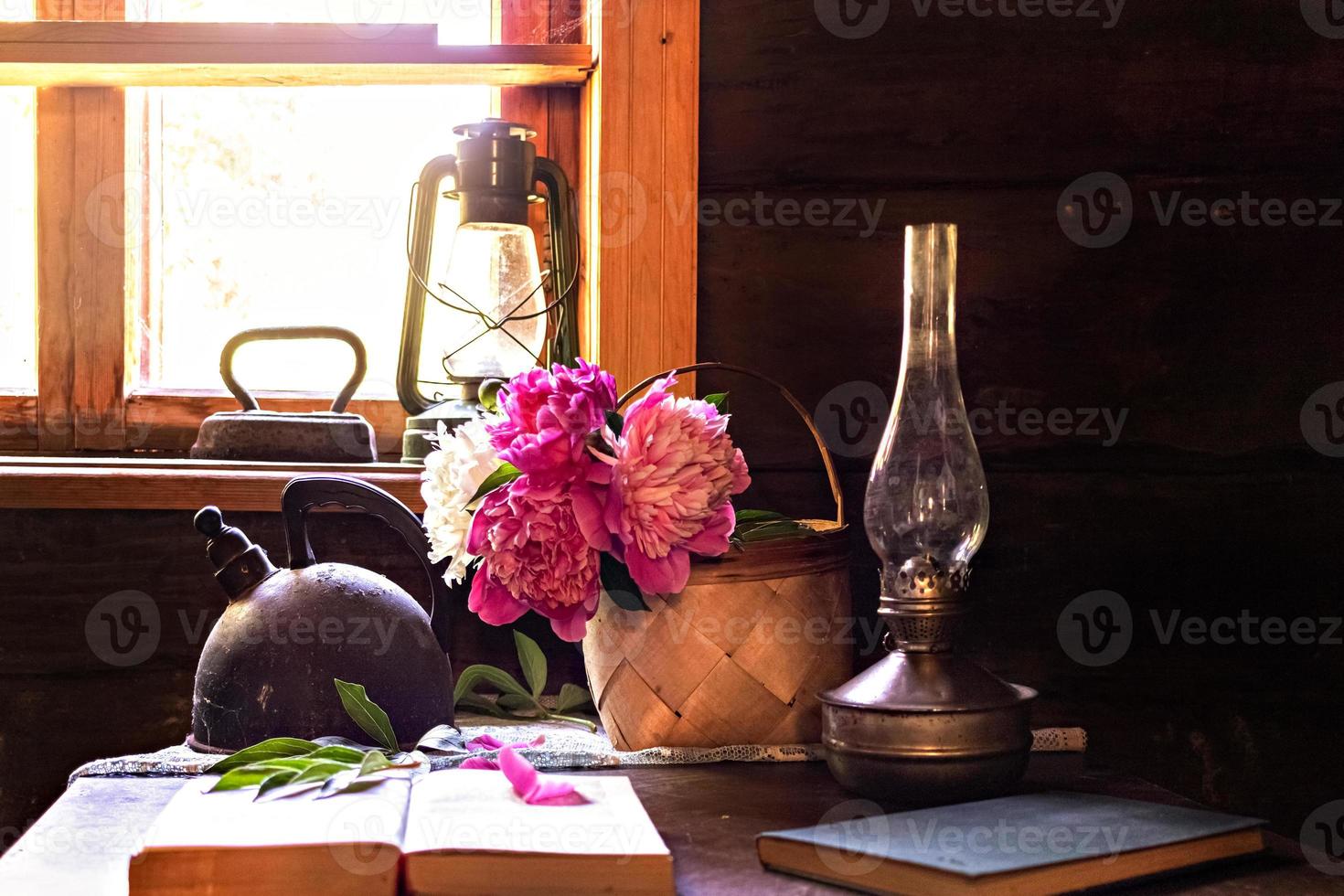 natura morta di oggetti vintage e un bouquet di peonie su un tavolo foto