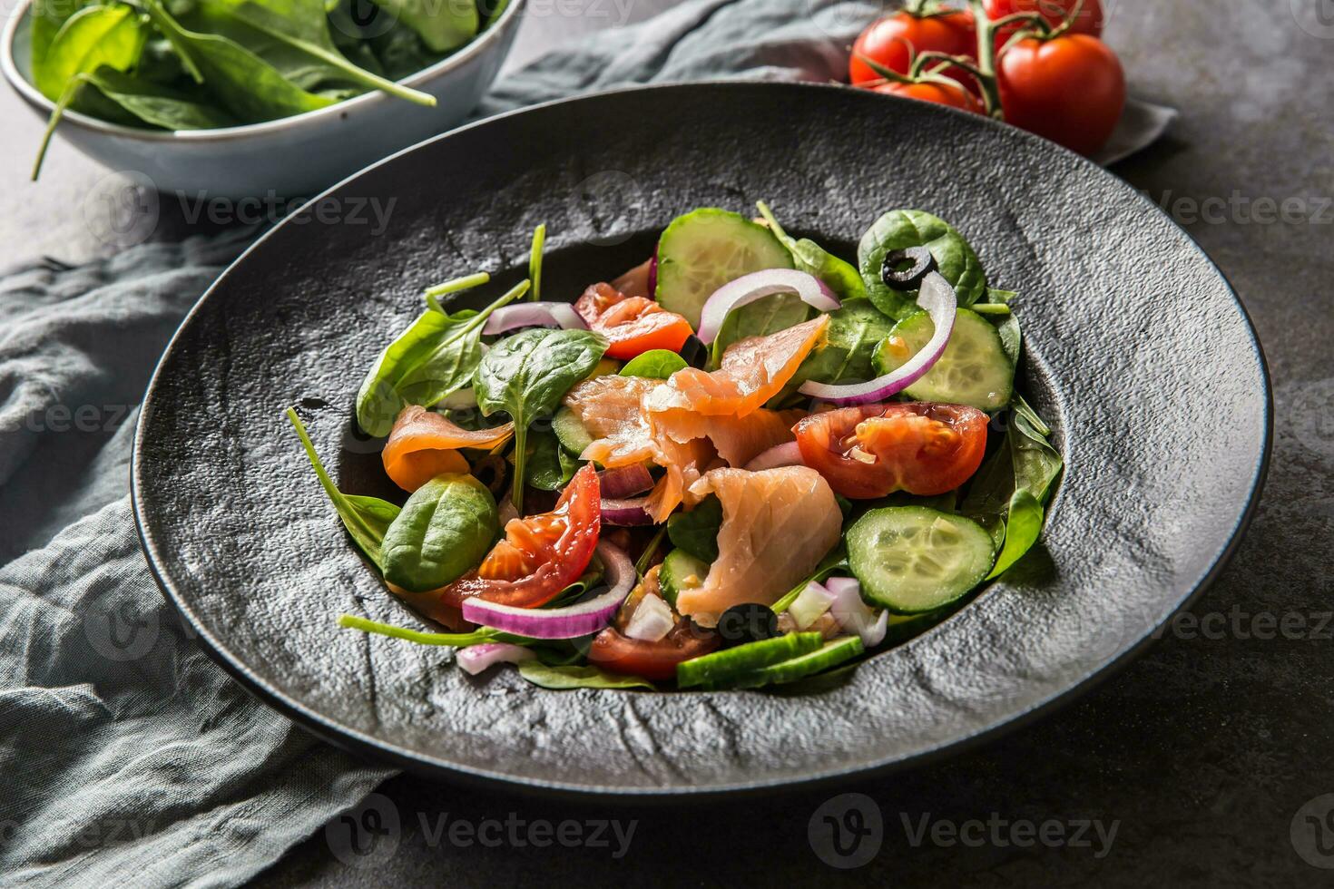 salmone insalata con verdura nel piatto su buio cucina tavolo foto