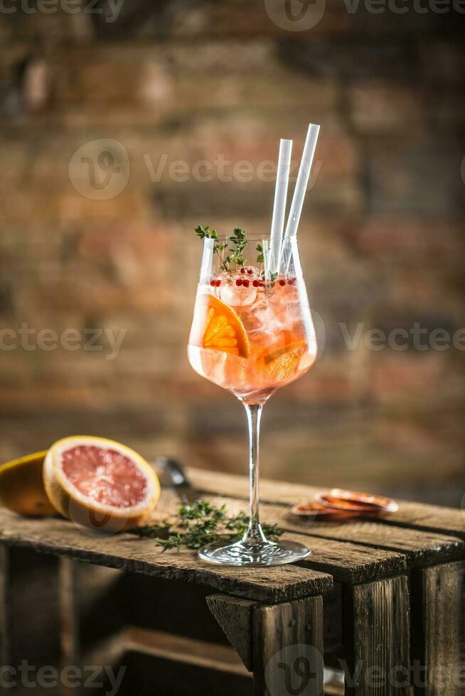 cocktail bevanda su un' vecchio di legno tavola. alcolizzato bevanda con tropicale frutta rosso Pepe erba e ghiaccio foto
