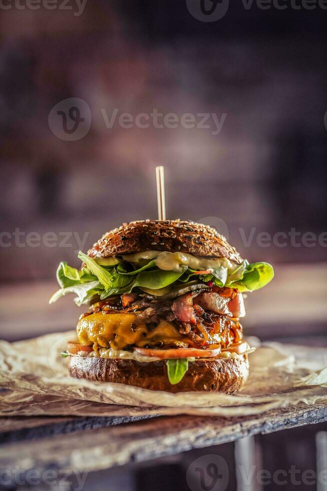 casa fatto gustoso hamburger con Bacon cipolla formaggio ane lattuga su di legno scatola foto