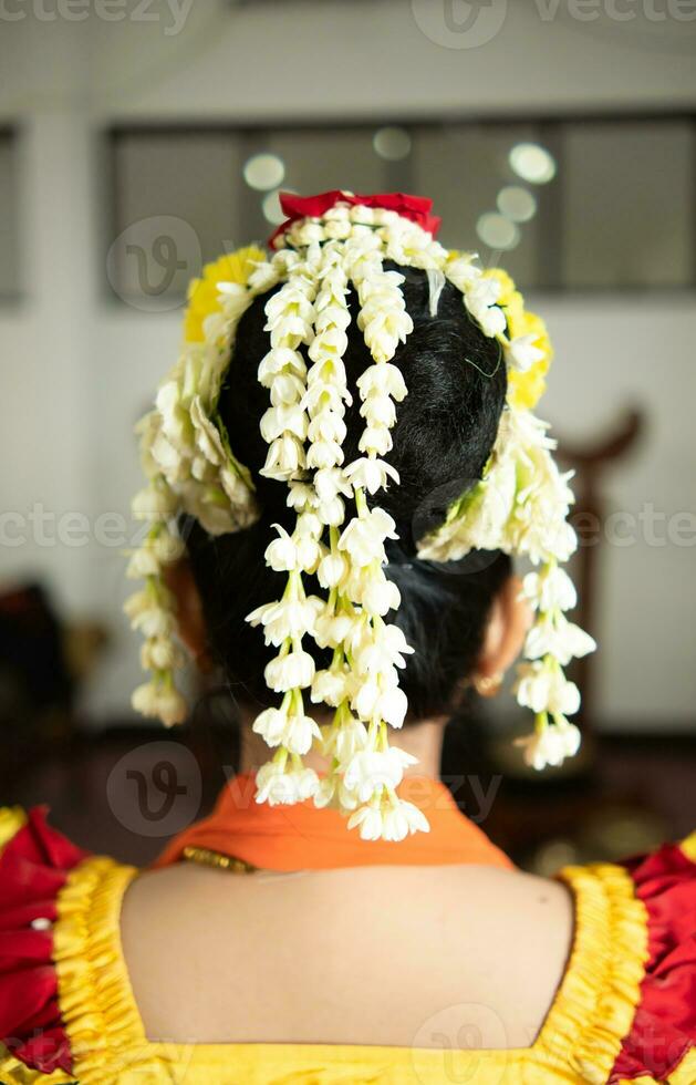 un' tradizionale giavanese ballerino indossa molto bellissimo gelsomino fiori nel sua nero capelli foto