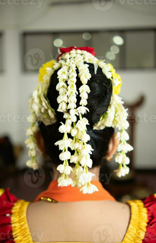 un' tradizionale giavanese ballerino indossa molto bellissimo gelsomino fiori nel sua nero capelli foto