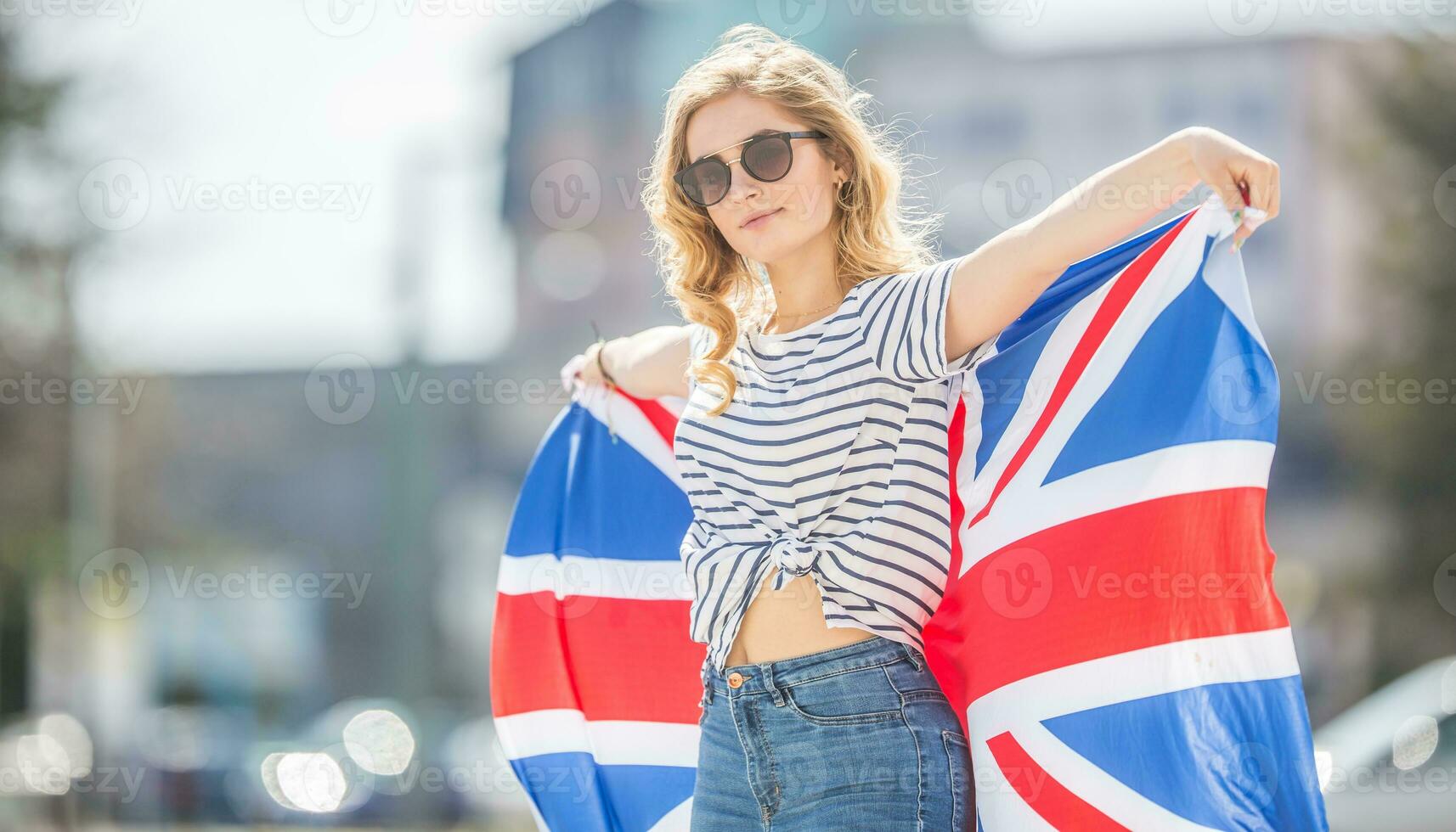 attraente contento giovane ragazza con il bandiera di il grande Gran Bretagna foto