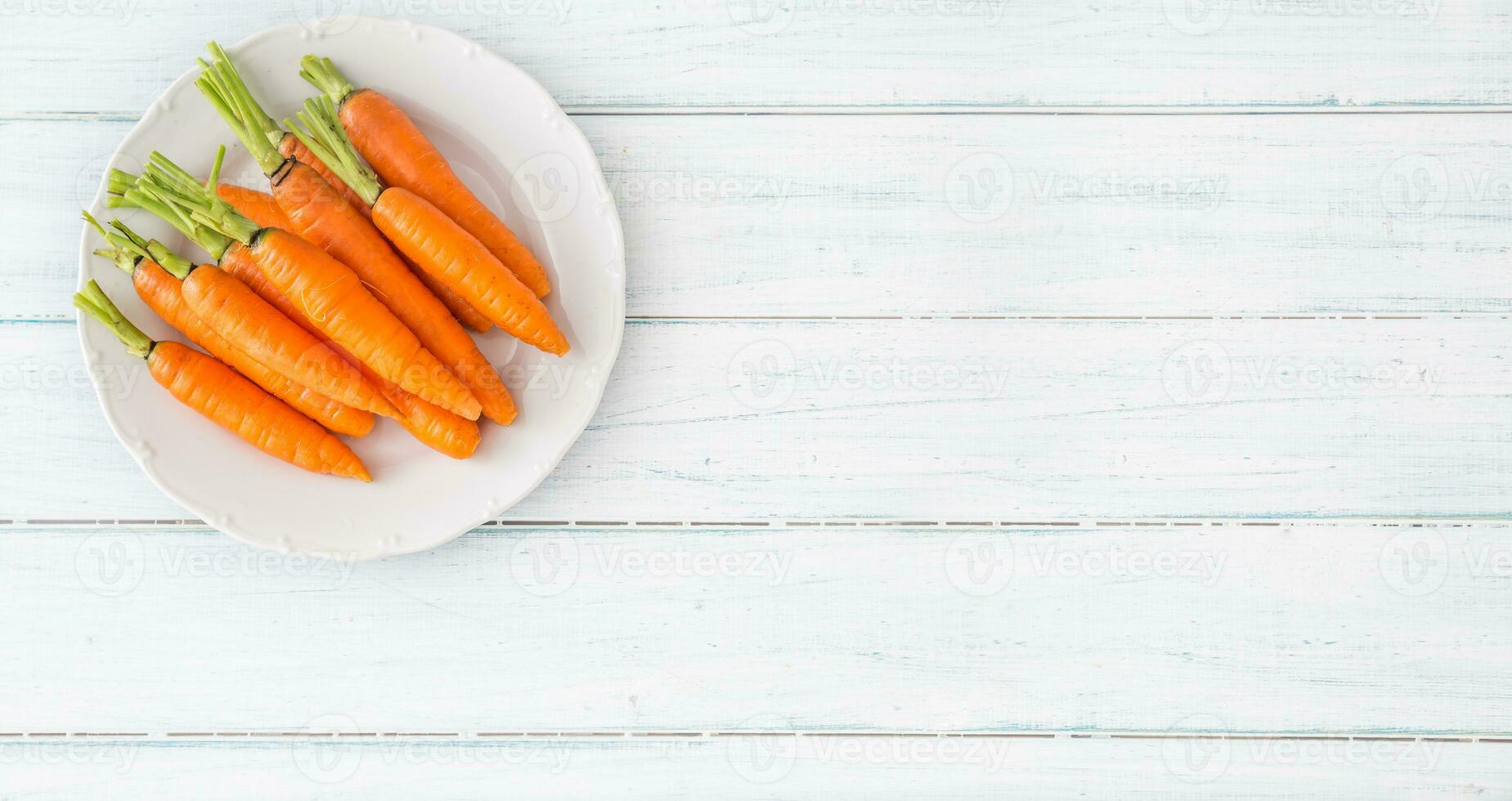 fresco carota su bianca piatto su tavolo - superiore di Visualizza foto