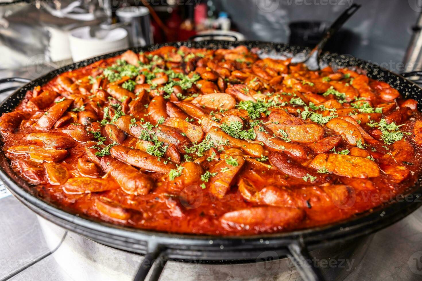 grande strada cibo padella pieno di rosso salsiccia stufato con prezzemolo su superiore di il venditore foto