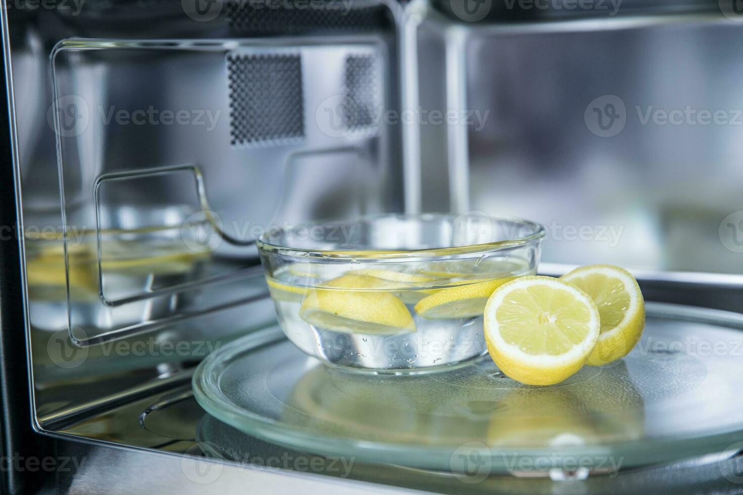 un' metodo di pulizia nel un' microonde forno con acqua e Limone foto