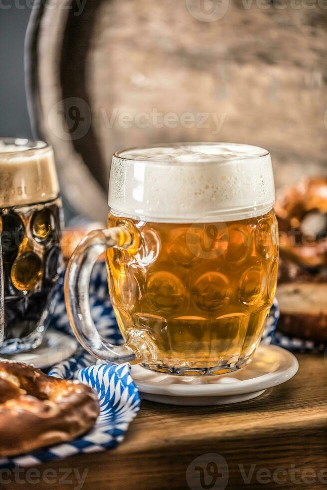 oktoberfest birra con salatino di legno barile e blu tovaglia foto