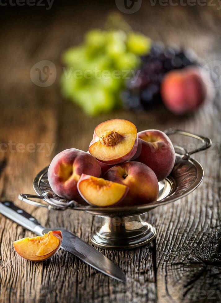 maturo Pesche nel rustico ciotola e di legno tavolo foto