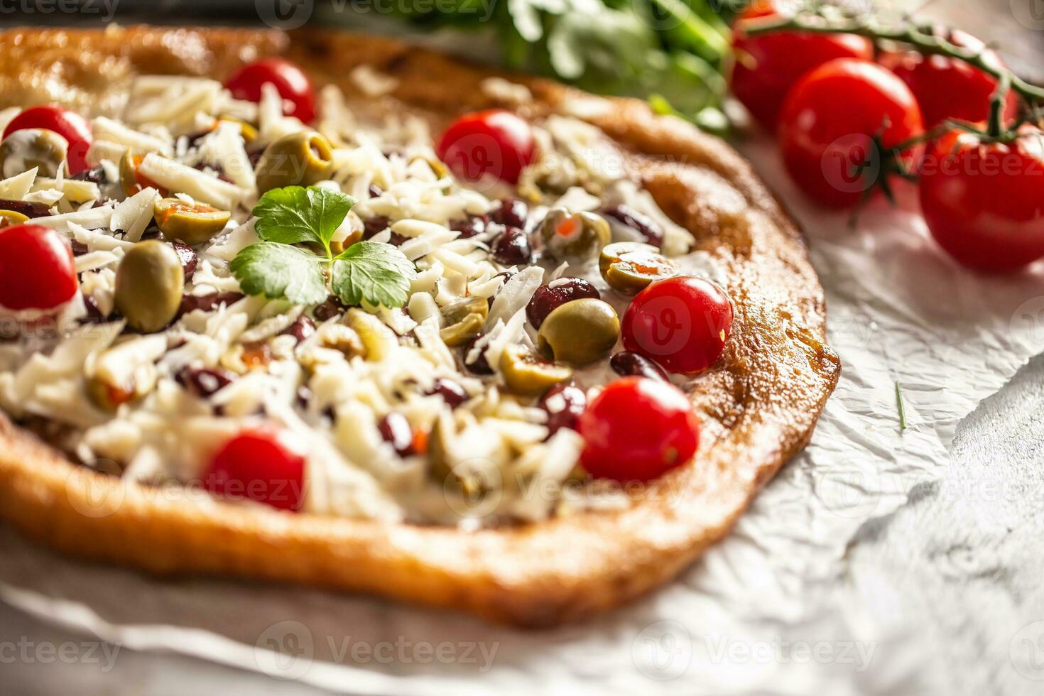 gustoso e croccante langos perfettamente servito con totale ciliegia pomodori, grattato formaggio, fagioli e verde greco olive foto