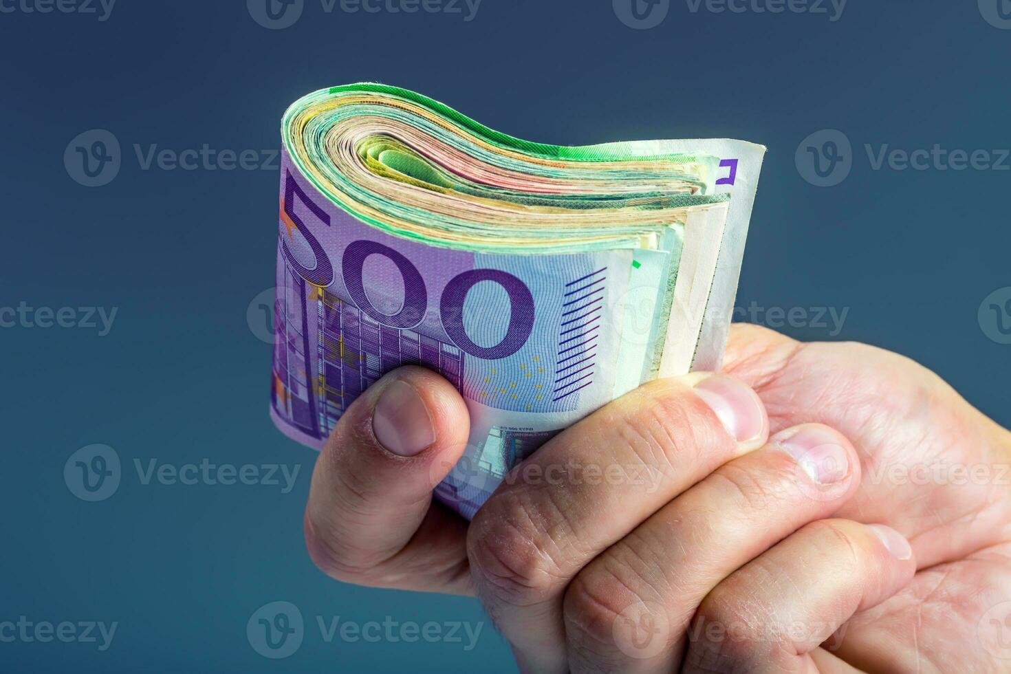maturo uomo Tenere un' fascio di i soldi nel il suo dita. Euro moneta banconote foto