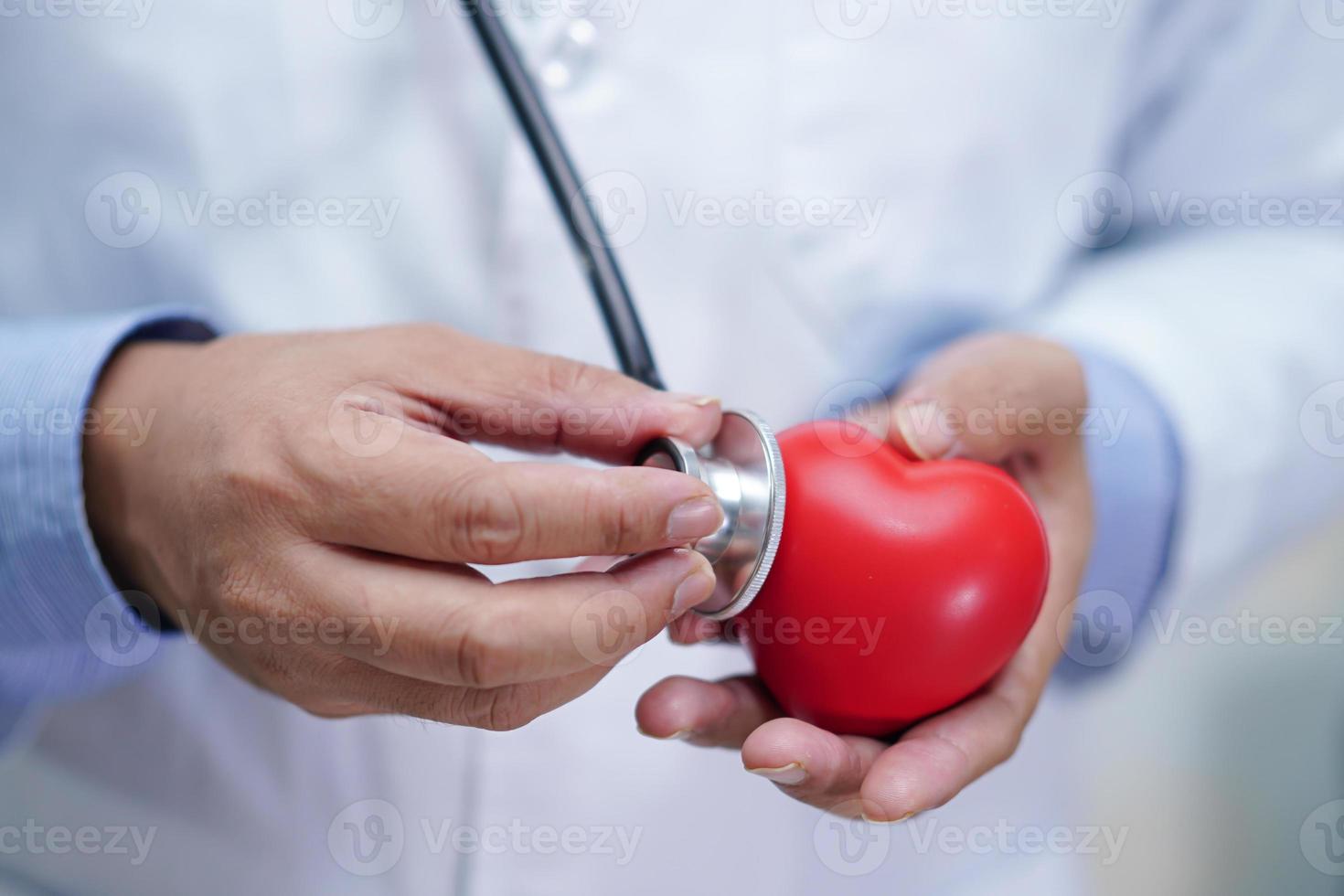 medico che tiene il cuore rosso in mano nel reparto ospedaliero di cura sano forte concetto medico. foto