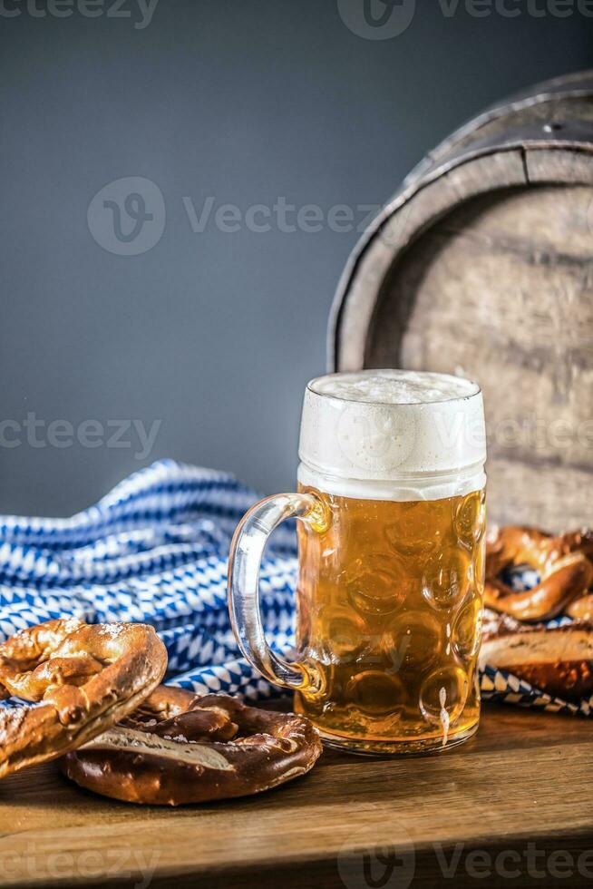 oktoberfest grande birra con salatino di legno barile e blu tovaglia foto