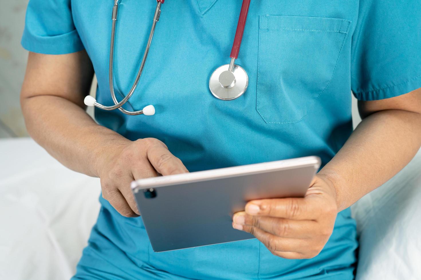 medico in possesso di tablet digitale per cercare dati per curare il paziente nel reparto ospedaliero di cura sano forte concetto medico. foto