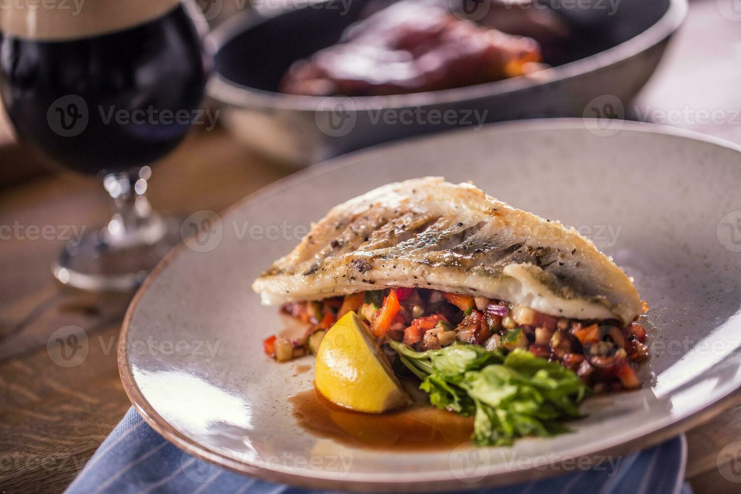 filetto di lucioperca con verdure su un' piatto nel un' ristorante foto