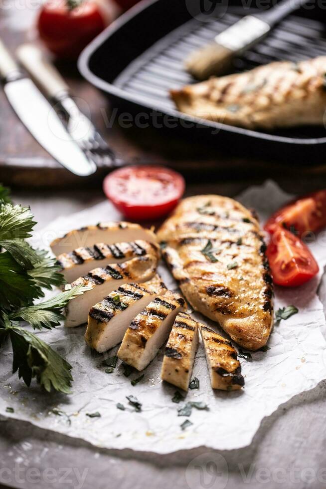 pollo Seno fette grigliato su carta con sedano erbe aromatiche e pomodori foto